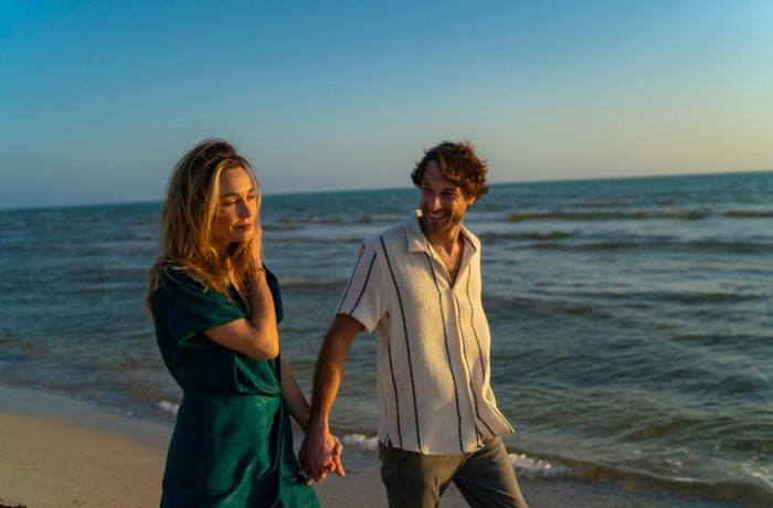 Couple walking on the beach at sunset